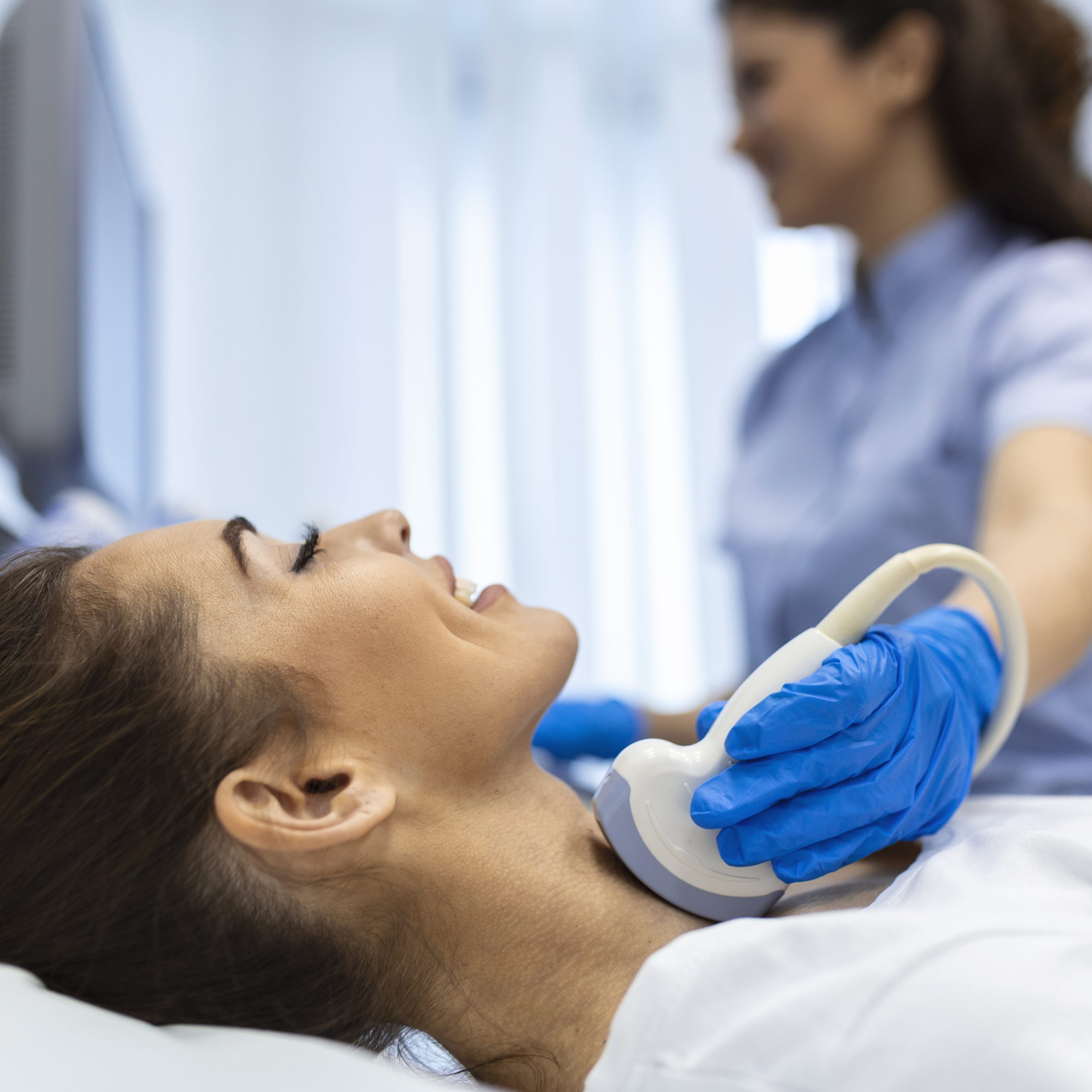 Woman patient receives thyroid diagnostics. Treatment of thyrotoxicosis, and hypothyroidism. Ultrasound diagnostics of the endocrine system and thyroid