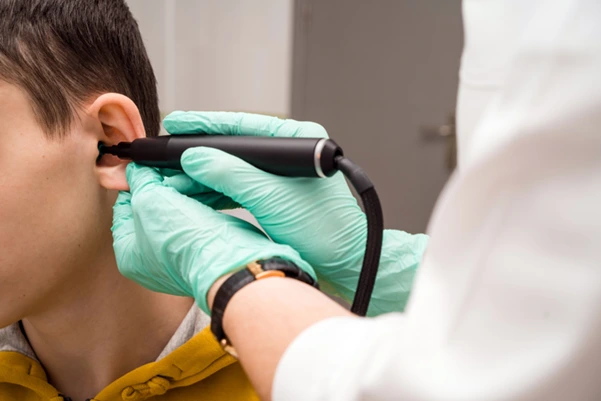 An ear specialist uses a video otoscope to examine a patient's ear