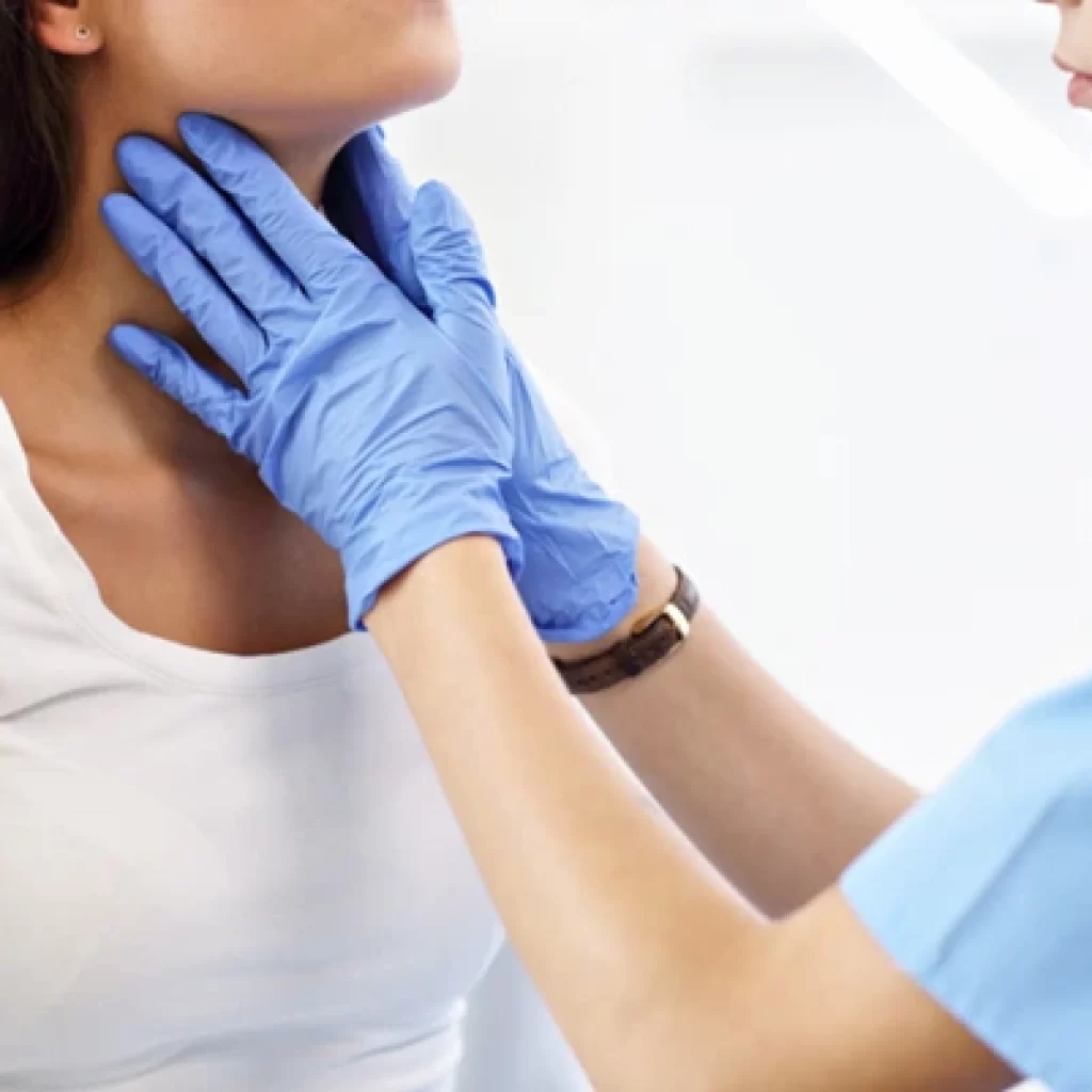A thyroid specialist performs a neck examination on a patient