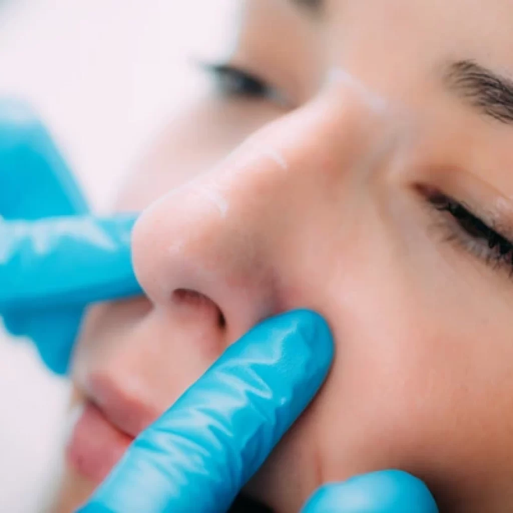 A nose specialist performing a nasal examination on a patient at Novena ENT