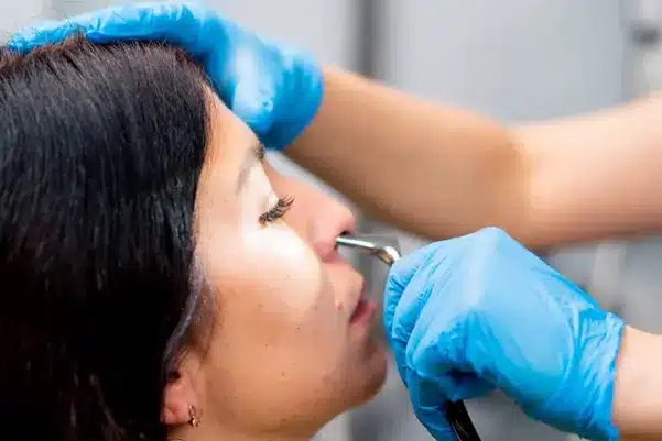 An ENT specialist performing a nasal endoscopy, a diagnostic procedure for accurately assessing a patient's sinus condition An ENT specialist performing a nasal endoscopy, a diagnostic procedure for accurately assessing a patient's sinus condition