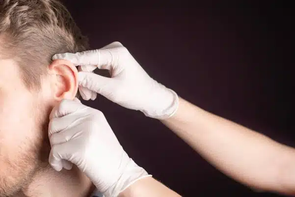 An ear specialist performing a safe and gentle ear cleaning procedure to a patient An ear specialist performing a safe and gentle ear cleaning procedure to a patient
