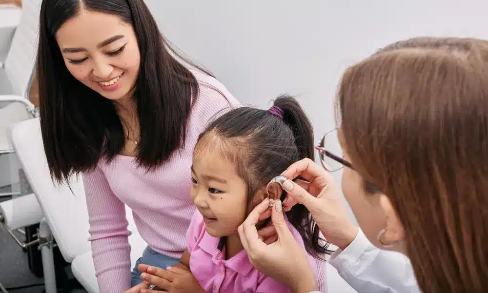 Pediatric hearing assessment at Novena ENT An ENT specialist examining a young girl's ear to assess suitability for a cochlear implant in Singapore