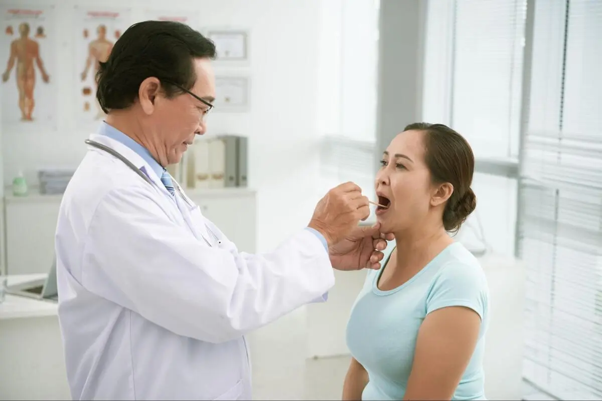 Professional Thyroid Diagnostic Examination A medical specialist in Singapore performing a physical examination of a patient’s throat.