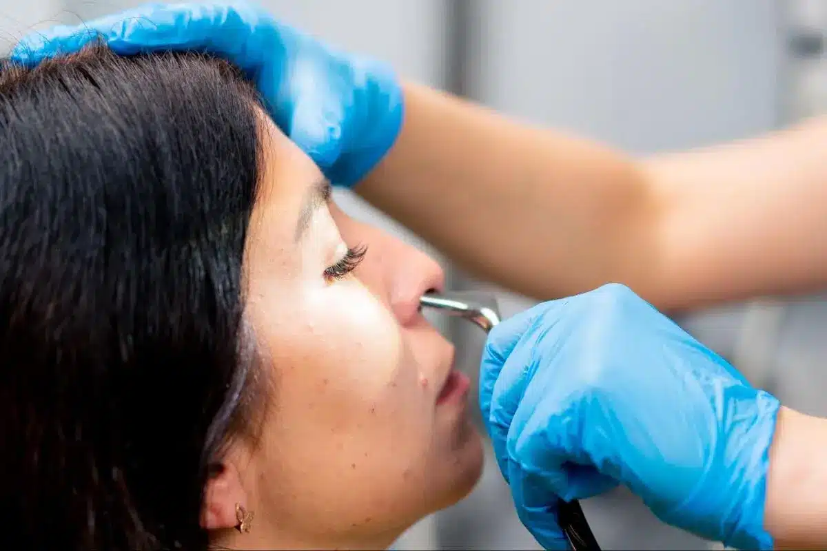 ENT Specialist Performing Nasal Examination ENT specialist examining a patient's nasal cavity using an endoscope instrument