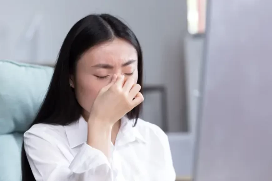A woman experiencing facial pain and pressure, a common symptom of sinusitis