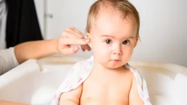 An ear specialist gently examines the ear of a young baby