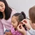 A child-friendly ear specialist at Novena ENT in Singapore examining a young girl's ear