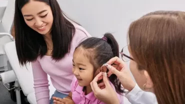 A child-friendly ear specialist at Novena ENT in Singapore examining a young girl