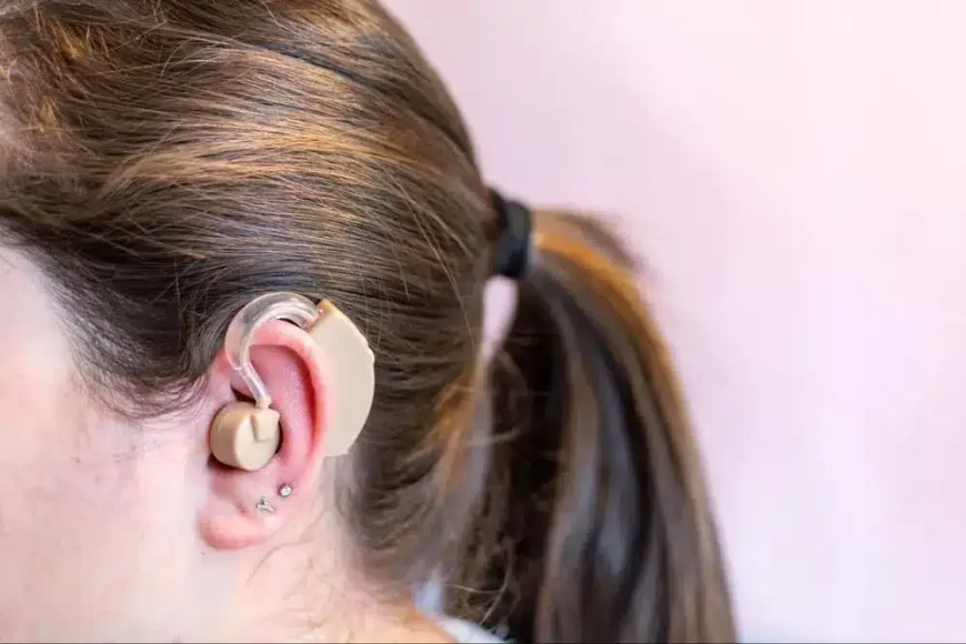 Close-up view of a woman wearing a cochlear implant behind her ear.